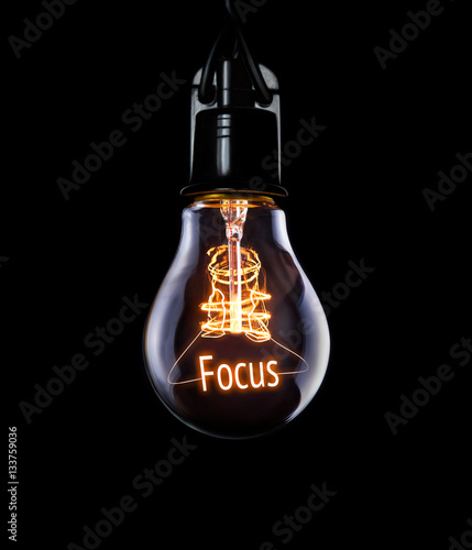 Hanging lightbulb with glowing Focus concept. photo
