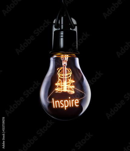 Hanging lightbulb with glowing Inspire concept.