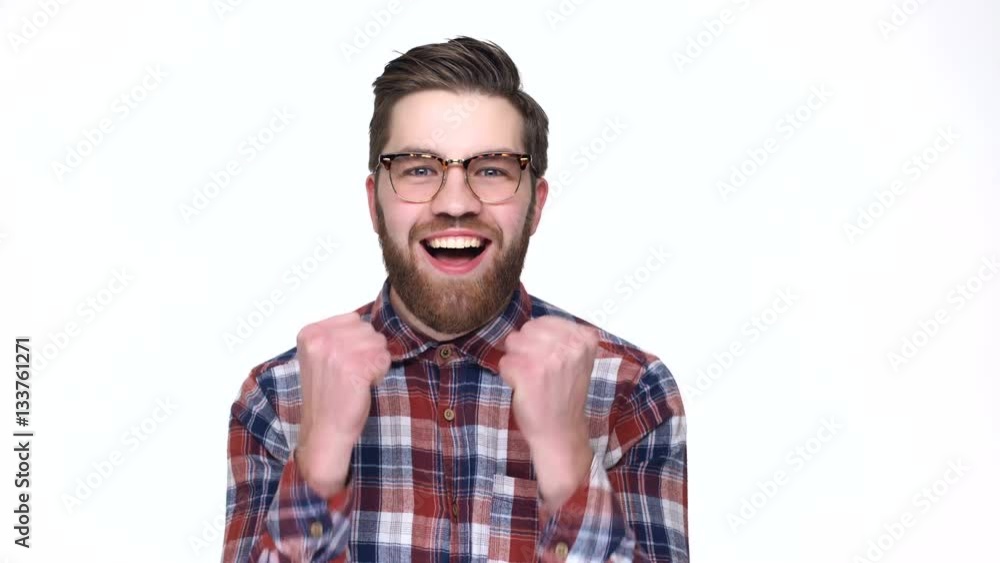 Happy young man expressing positivity and gesturing while standing isolated on white background Happy young man expressing positivity and gesturing while standing isolated on white background