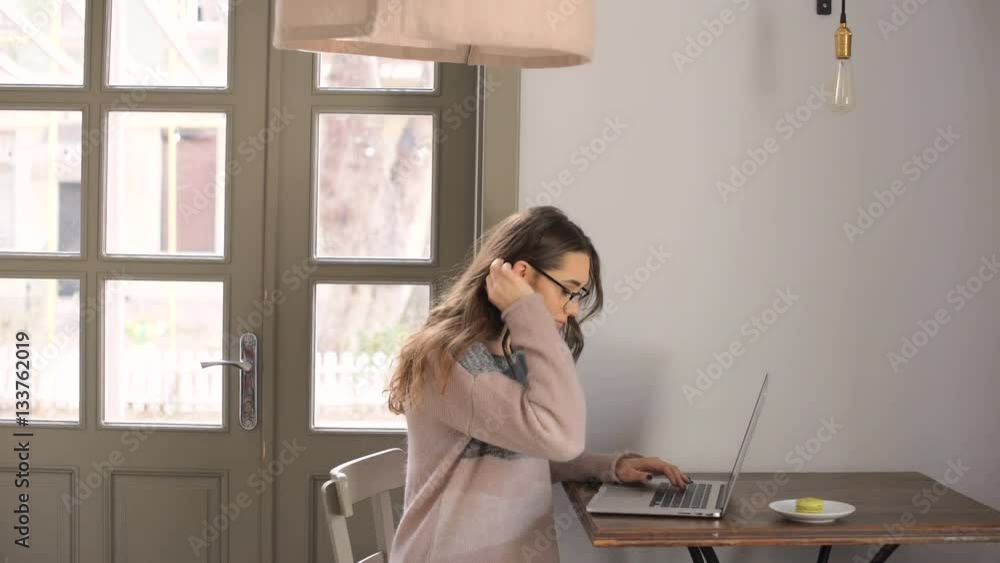 Beautiful young woman with long hair sitting at the table in cafe and using laptop Beautiful young woman with long hair sitting at the table in cafe and using laptop