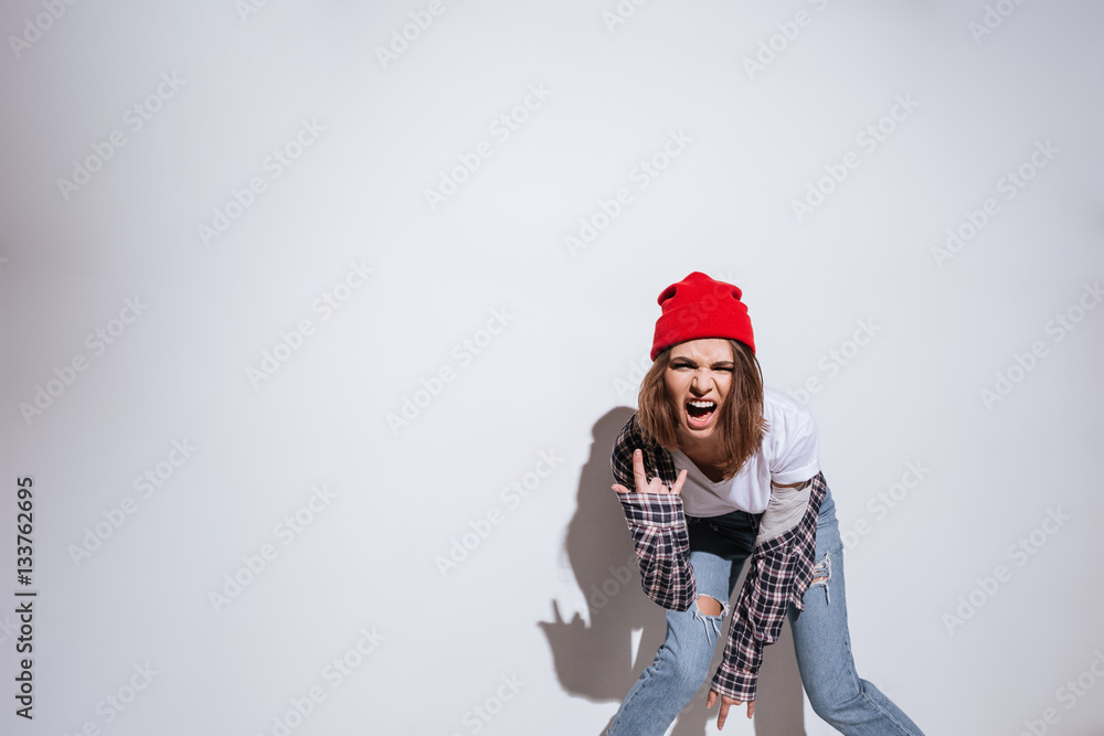 Woman dressed in shirt in cage print make rock gesture Woman dressed in shirt in cage print make rock gesture