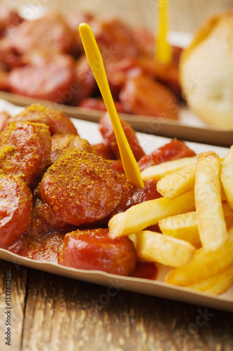 Traditional German currywurst, served with chips on disposable p