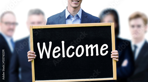 young businessman holding up a chalkboard with word Welcome