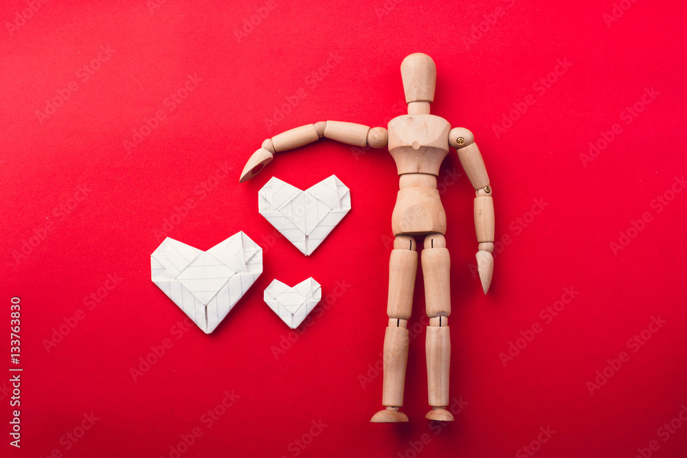 wooden dummy and paper harte on red background,love concept wooden dummy and paper harte on red background,love concept