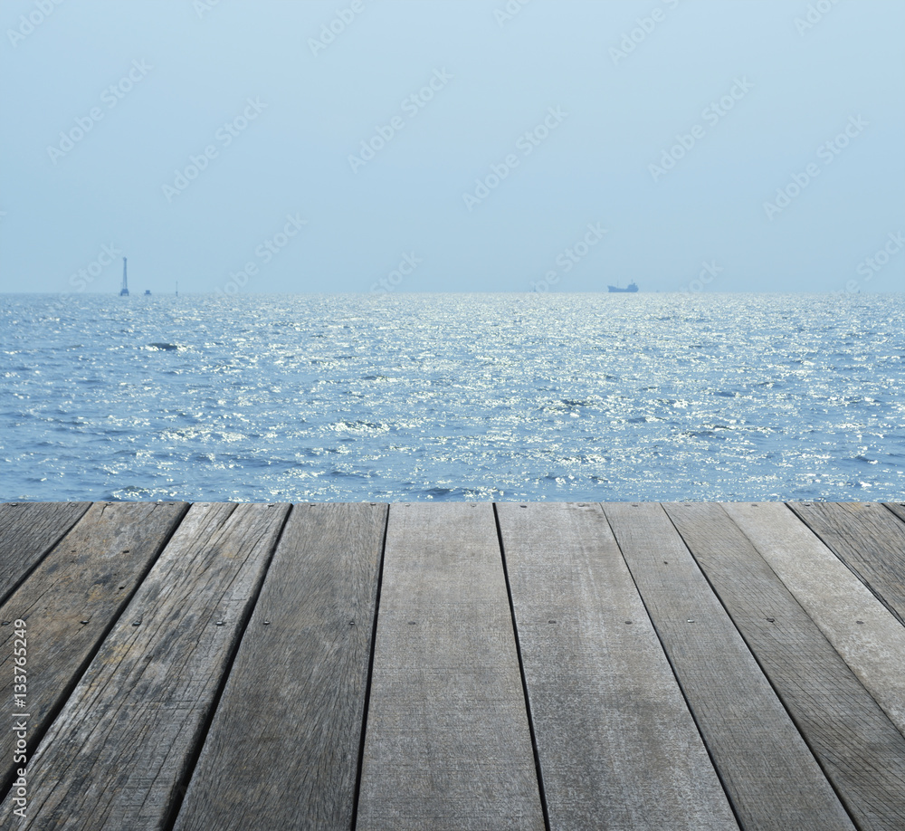 Empty old wood floor over boat silhouette with sea and blue sky Empty old wood floor over boat silhouette with sea and blue sky