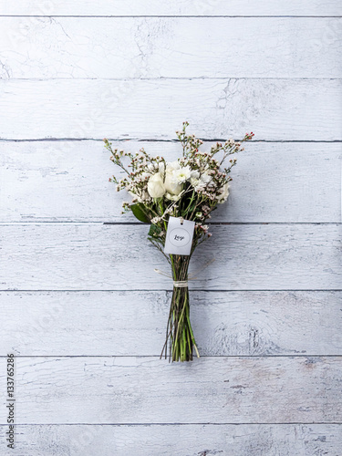 weiße rosen als strauß gebunden auf dem boden liegend von oben fotografiert