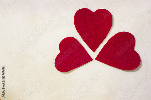 Foto A three decorative red hearts on light background