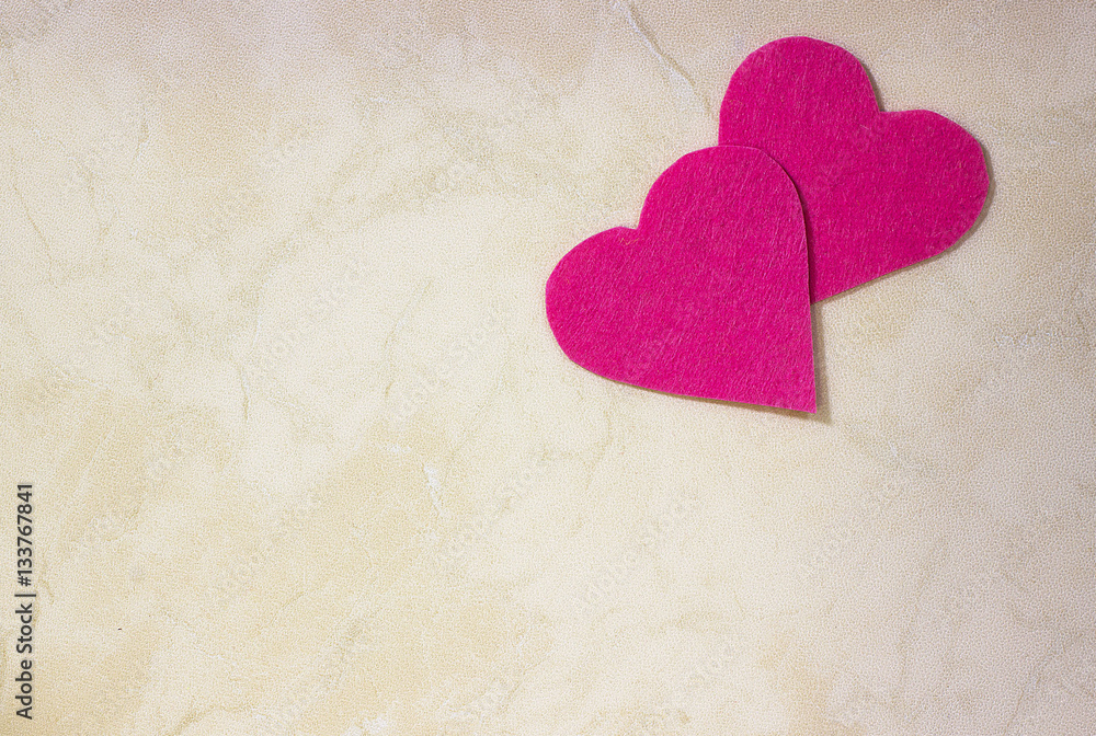 A two decorative fuchsia hearts on light background A two decorative fuchsia hearts on light background