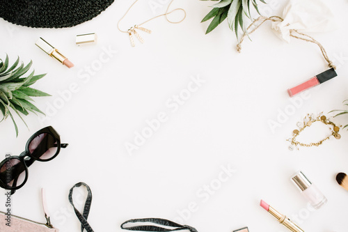 Summer casual style. Frame of modern woman clothes and accessories collage. Dress, sunglasses, hat, purse, lipstick and pineapples. Flat lay, top view photo