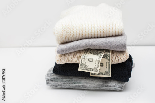 Stack of sweaters and couple dollars among them