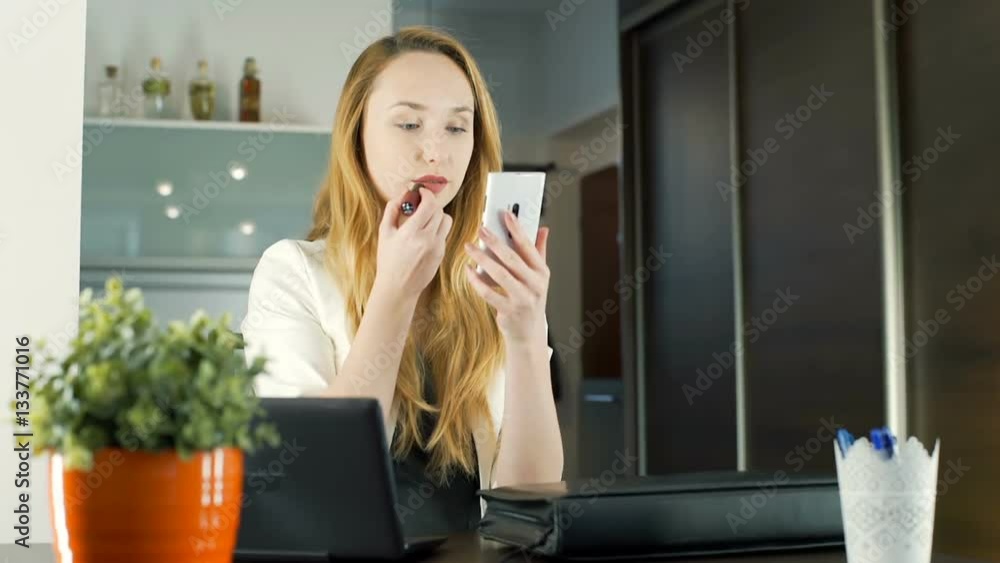 Businesswoman using smartphone as a mirror while painting lips, steadycam shot
Businesswoman using smartphone as a mirror while painting lips, steadycam shot