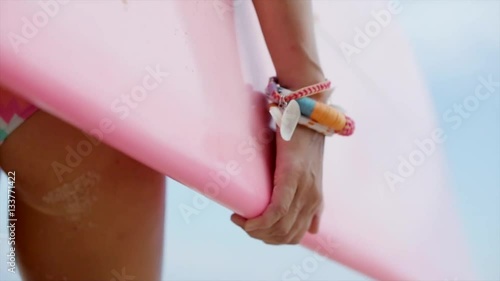 Beautiful sexy woman in bikini goes with surfboards