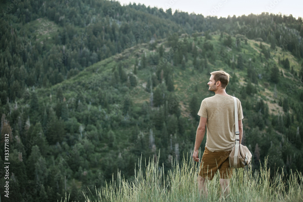 A man in the mountains standing looking around him. A man in the mountains standing looking around him.