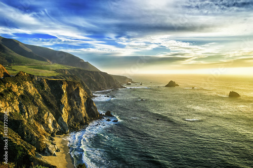 The coastline at Big Sur in California, with steep cliffs and rock stacks in the Pacific Ocean.  photo