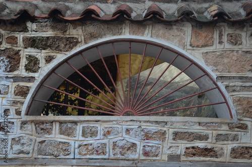 window in the stone wall with grating