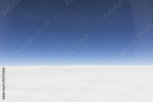 the sky when i am looking through window aircraft during flight in wing with a blue sky. © sirnength88