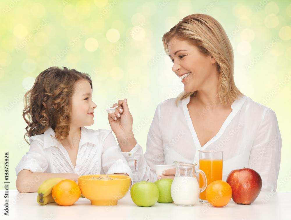 happy mother and daughter eating healthy breakfast happy mother and daughter eating healthy breakfast