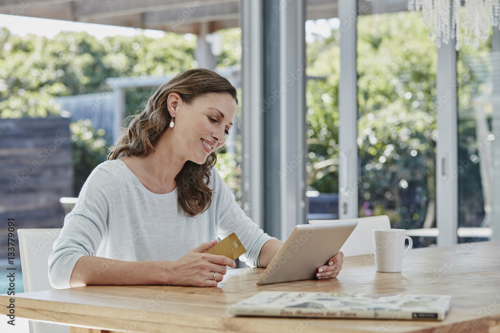 Woman sitting on terrace, doing online payment with credit card Woman sitting on terrace, doing online payment with credit card