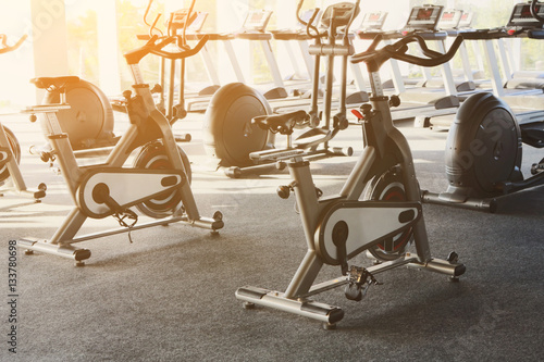 Modern gym interior with equipment, fitness exercise bikes
