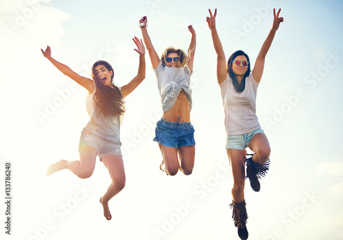 Three agile energetic teenagers leaping in the air