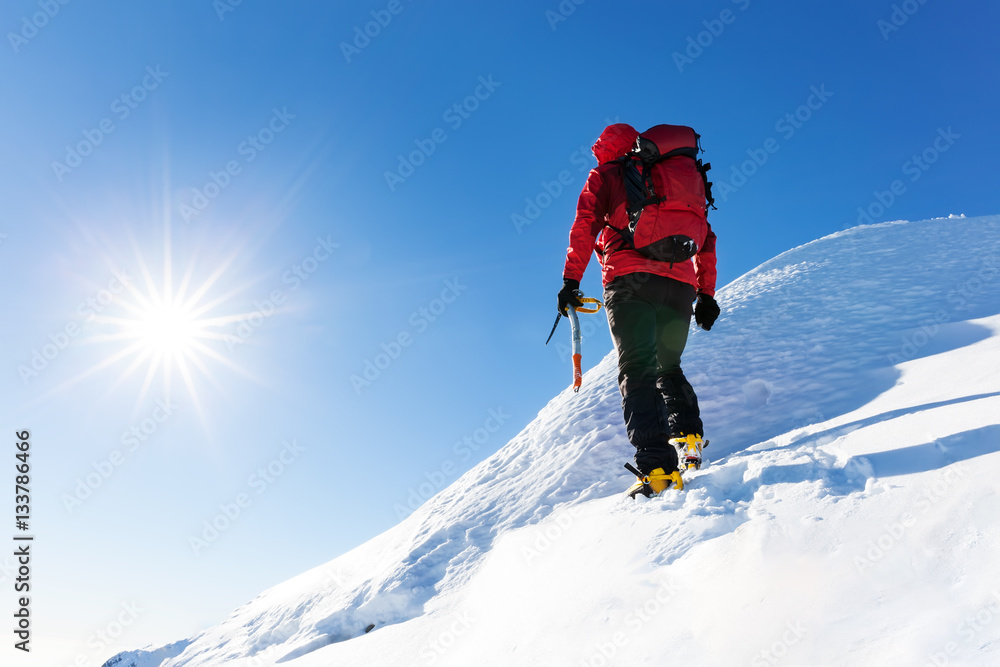 Extreme winter sports: climber reachs the top of a snowy peak in the Alps. Concepts: determination, success, brave.