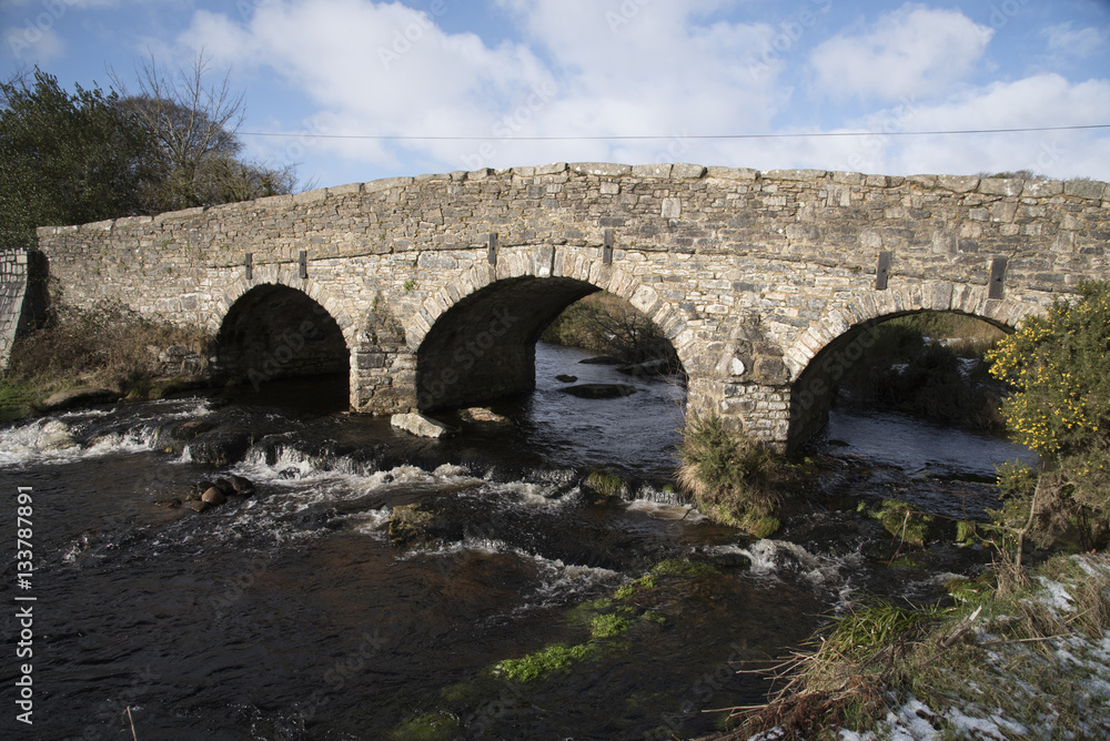 The  East Dart River and road bridge built in the 1700's at Postbridge on Dartmoor in Devon England UK. January 2017