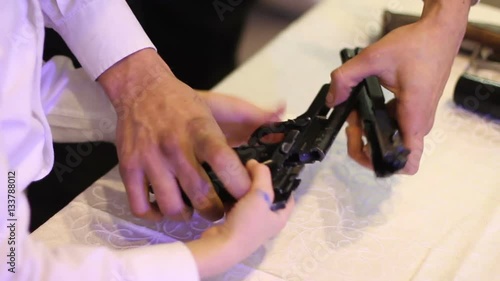 man showing a boy how to disassemble the gun