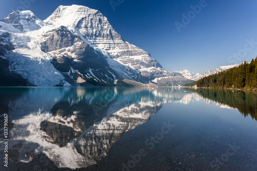 Panoramic view of Mt Robson mountain with glacier and lake during day with amazing summer colors in daylight and blue sky no clouds and mirror reflection in the water , Canadian Rockies in Canada.