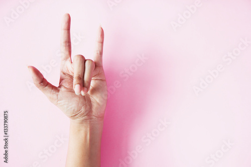 I LOVE YOU hand sign on pink background with copy space