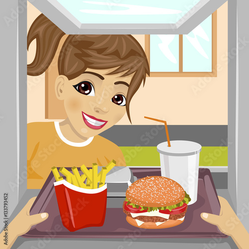 hands giving tray with fast food meals through a drive-thru window to happy teenager girl