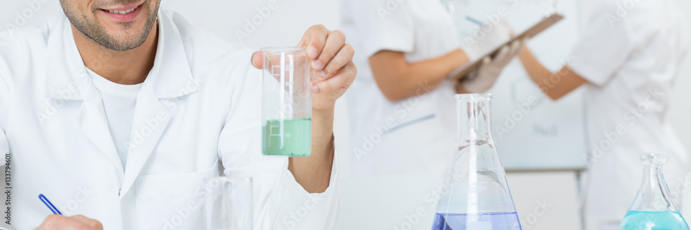 Scientist looking at beacon with liquid Scientist looking at beacon with liquid