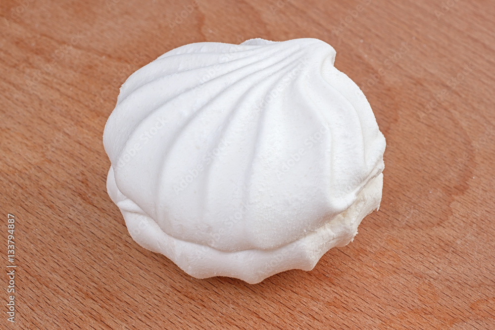 One white airy sweet marshmallow zephyr on wooden background