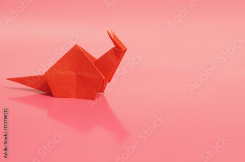 Paper origami snail isolated on a colorful background