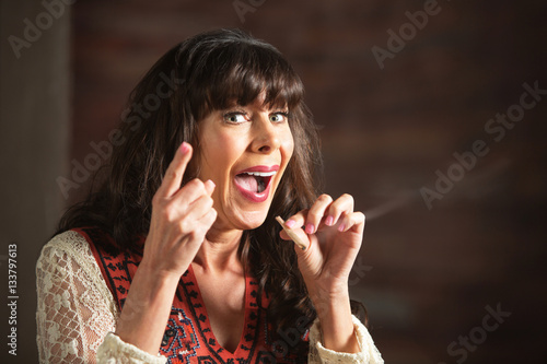 Fotografija Laughing woman pointing finger while smoking pot