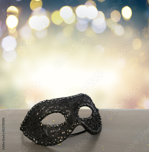 Mask on wooden table border isolated on bokeh background with copy space