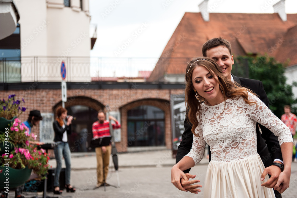 gorgeous happy wedding couple walking and kissing in the old city of Minsk, Belarus