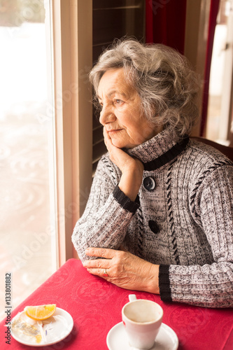 Canvastavla Lonely senior woman sitting and drinking tea in restaurant