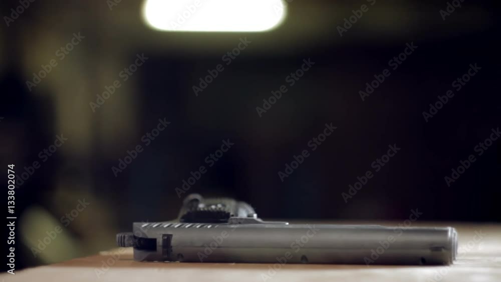 Man puts a gun on the table close-up Man puts a gun on the table close-up