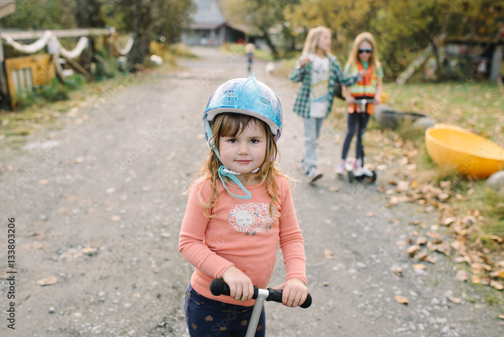 Female child and scooter with protective headwear Female child and scooter with protective headwear