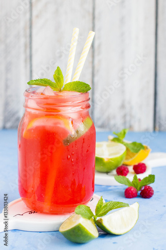 Wallpaper Mural Raspberry lemonade with lemon, lime, mint and ice in the glass on the blue table background. Summer drink Torontodigital.ca