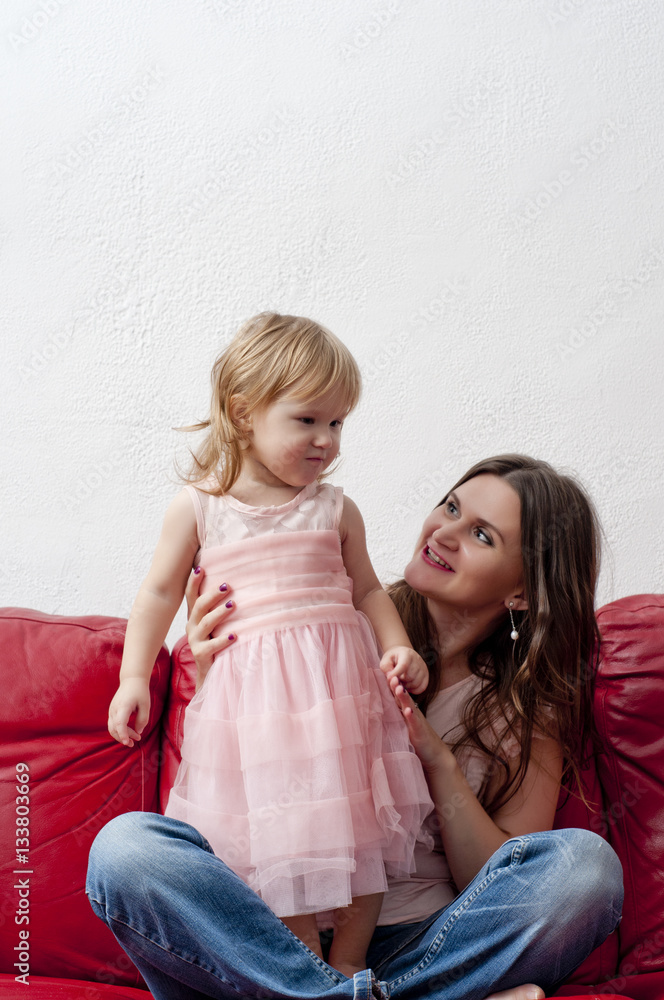Young mother playing with her daughter on the sofa Young mother playing with her daughter on the sofa