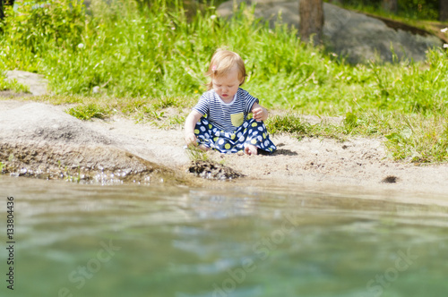 Little girl playing on the river bank