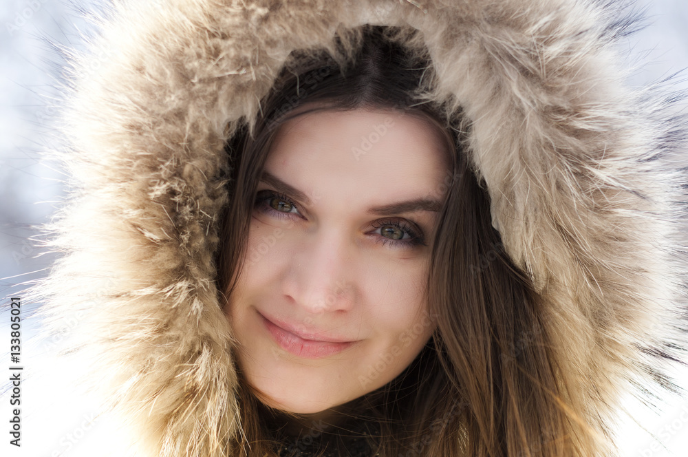 Beautiful girl in the hood with fur winter