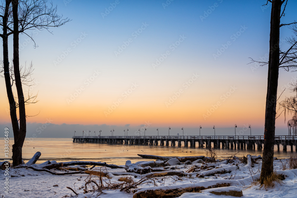 Obraz premium Zimowy wschód słońca z widokiem na molo