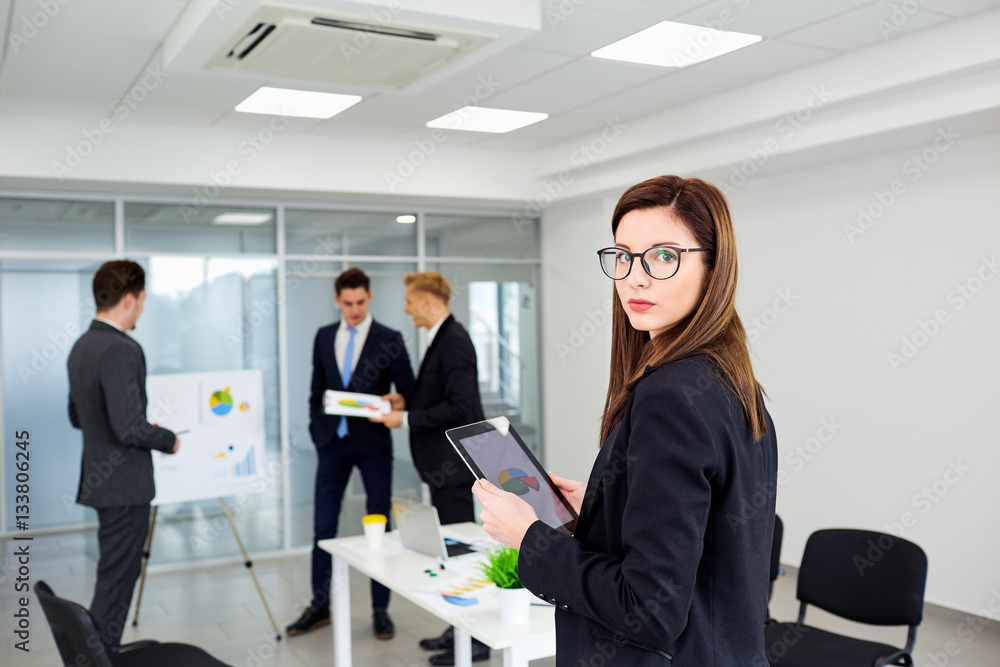 Businesswoman brunette in glasses on background business people a office. Businesswoman brunette in glasses on background business people a office.