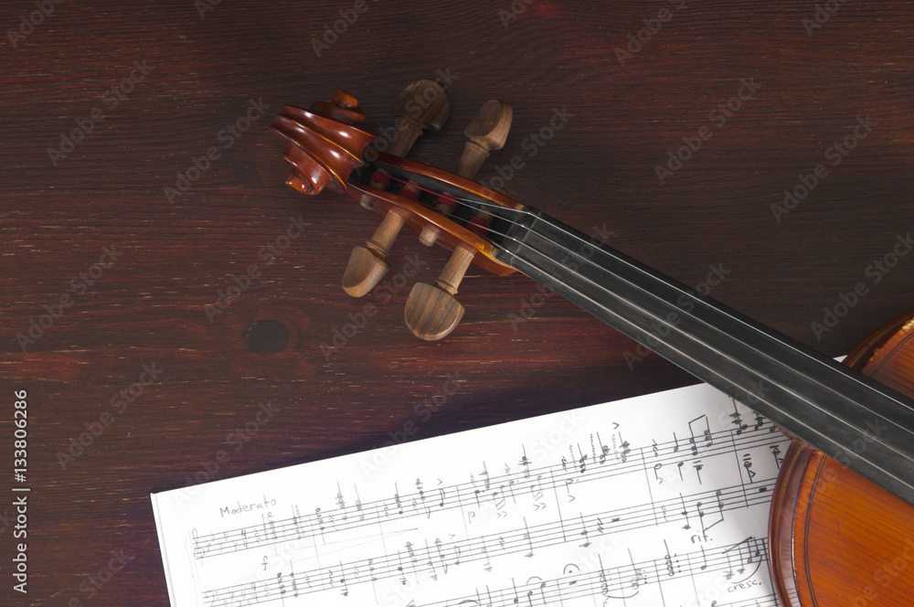 Naklejka premium Music notes and violin on table