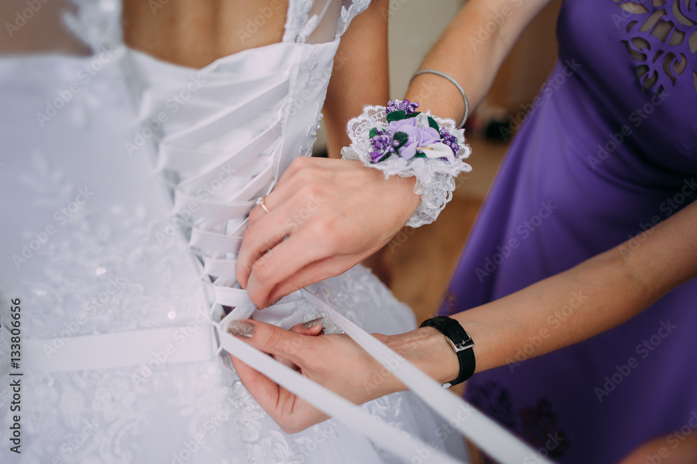 bridesmaid tying bow on wedding dress bridesmaid tying bow on wedding dress