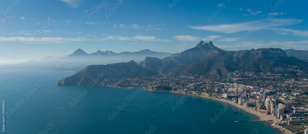 View over Calpe (Calp) town, Spain. Shot from the Penon  ( Ifach) rock, overlooking the coast, the harbor and Sierra de Bernia mountains