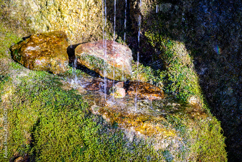 Obraz na plátně Drops of water falling on the stone and divided into shallow particles