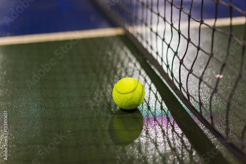 Tennis ball and net on wet ground after raining © Hanoi Photography